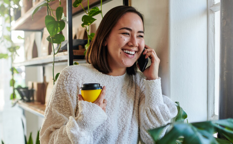 Woman holding coffee cup and smartphone